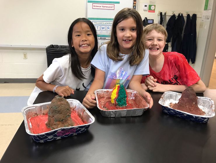 Campers smiling with model volcanoes