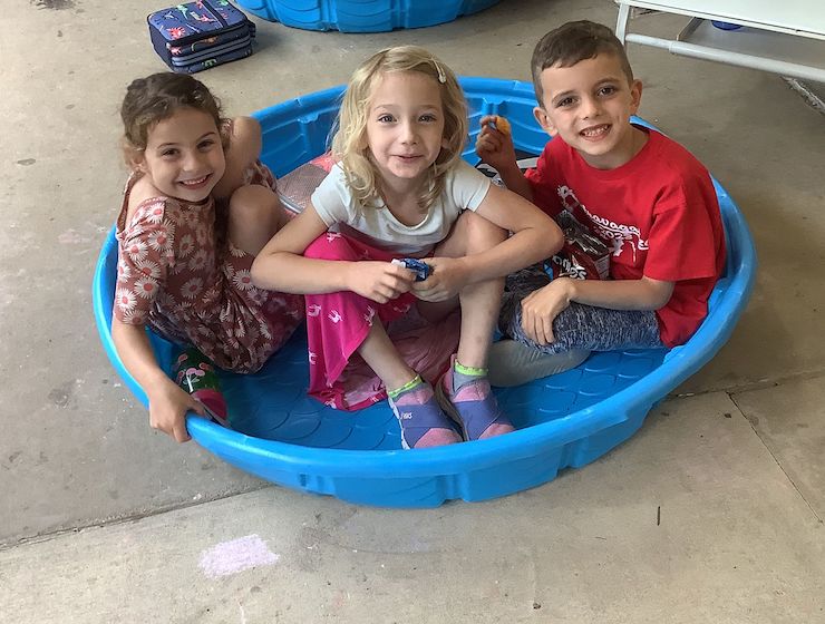 Campers sitting in an empty kiddie pool